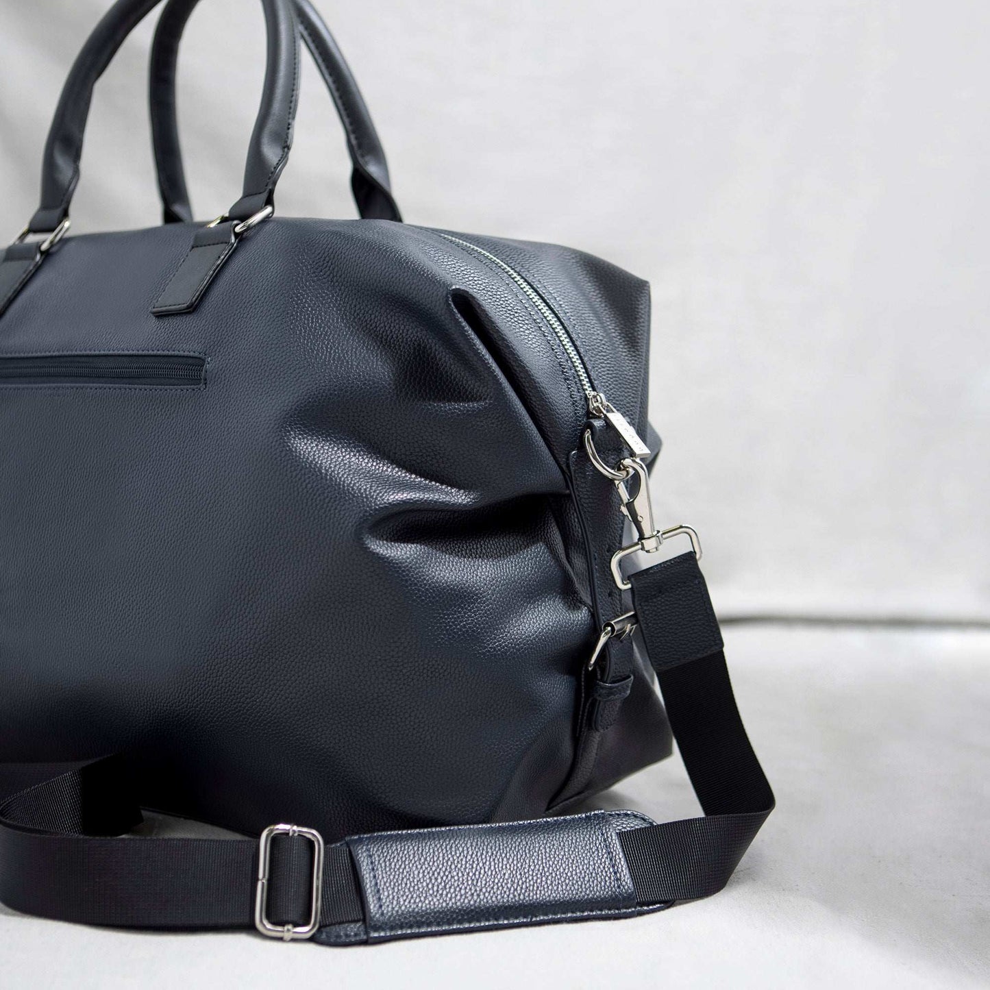 Bugatti Contrast vegan leather duffle bag in navy blue against a white background.