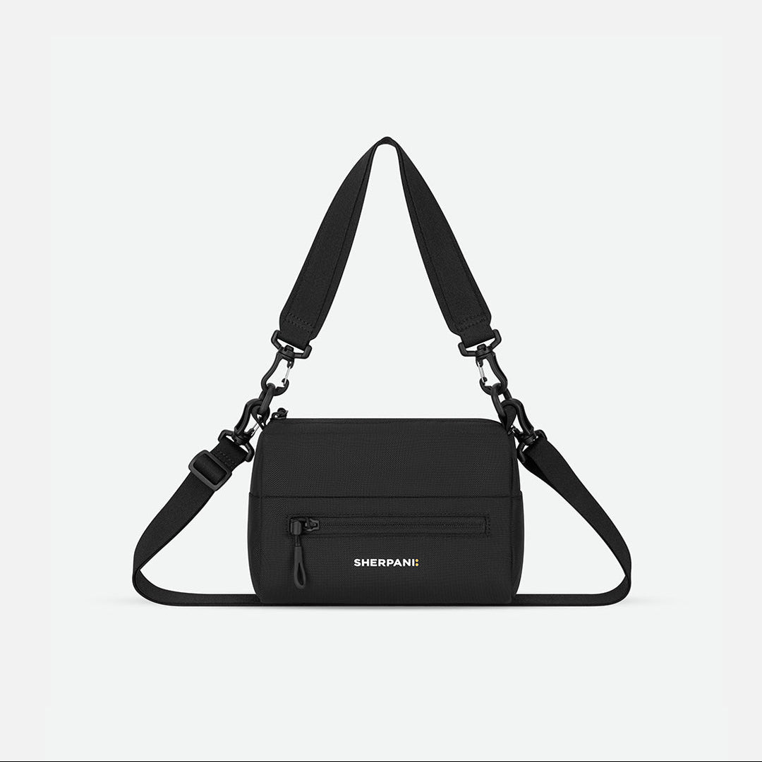 Black shoulder bag with adjustable strap on a light gray background