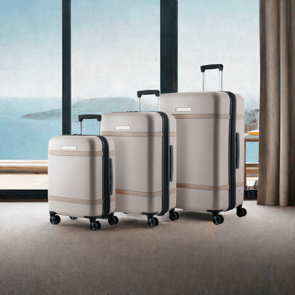 Tan Bugatti Wellington 3 piece luggage set in a hotel room overlooking the ocean.